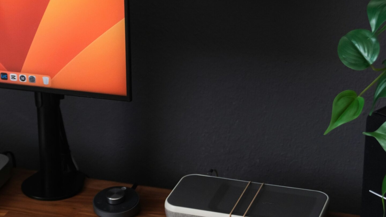 a desk with a laptop, keyboard, mouse and a monitor